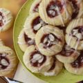 Dark Rum Cherry Almond Thumbprint Cookies - What's better than a Christmas thumbprint cookie? A boozy Christmas thumbprint cookie made using dark rum and cherry preserves. Add on a drizzle of powdered sugar rum glaze and a few sliced almonds, and these boozy Christmas cookies will certainly grab your attention with their festive presentation if not their amazing and absolutely delicious taste.