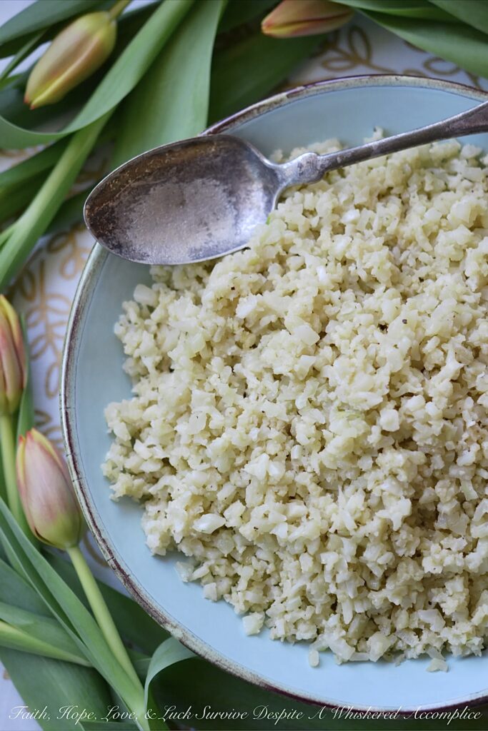 Garlicky Asiago Cauliflower Rice - The garlic seasoning and Asiago cheese in this garlicky cauliflower rice, really pack a punch, making this five-ingredient low-carb vegetable side dish a real weeknight winner.