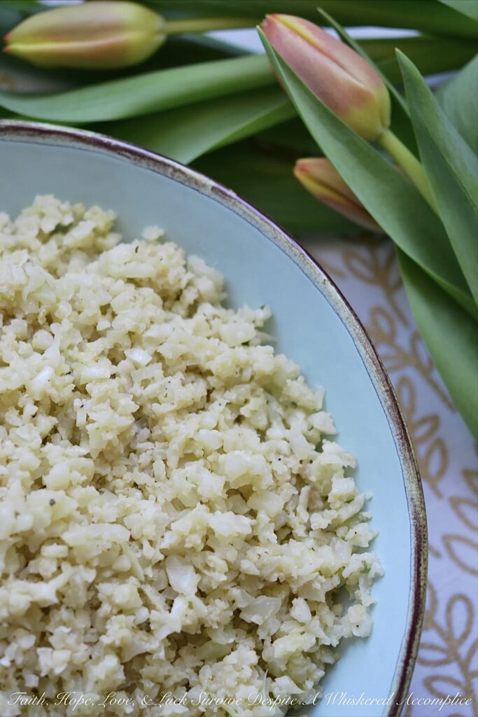 Garlicky Asiago Cauliflower Rice - The garlic seasoning and Asiago cheese in this garlicky cauliflower rice, really pack a punch, making this five-ingredient low-carb vegetable side dish a real weeknight winner.