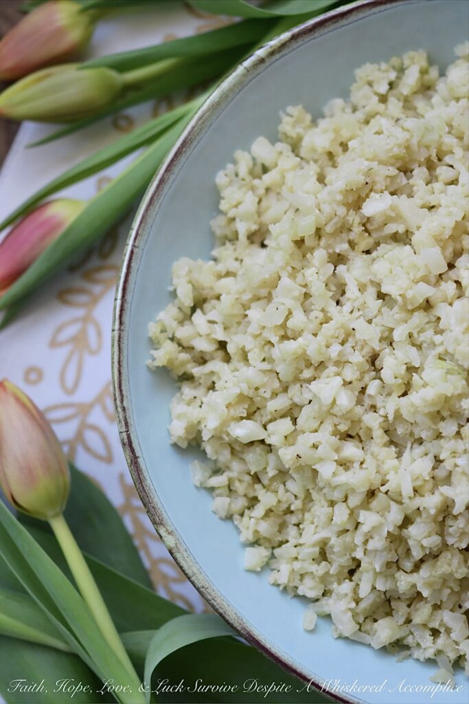 Garlicky Asiago Cauliflower Rice - The garlic seasoning and Asiago cheese in this garlicky cauliflower rice, really pack a punch, making this five-ingredient low-carb vegetable side dish a real weeknight winner.