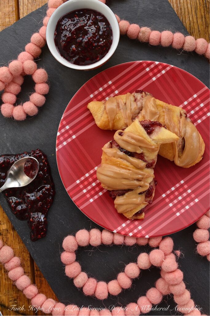 Raspberry & Peanut Butter Glazed Crescent Rolls - Are you a huge PB&J fan? Are peanut butter and jelly two of your favorite can't live without ingredients? If so, you're going to totally swoon over these raspberry and peanut butter glazed crescent rolls. I mean, how can you resist a crescent roll stuffed with raspberry preserves, jam, or jelly? Especially when it's topped with a smooth, creamy, and decadent peanut butter glaze.