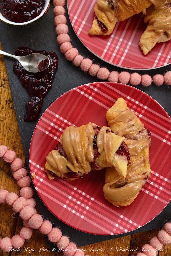 Raspberry & Peanut Butter Glazed Crescent Rolls - Are you a huge PB&J fan? Are peanut butter and jelly two of your favorite can't live without ingredients? If so, you're going to totally swoon over these raspberry and peanut butter glazed crescent rolls. I mean, how can you resist a crescent roll stuffed with raspberry preserves, jam, or jelly? Especially when it's topped with a smooth, creamy, and decadent peanut butter glaze.