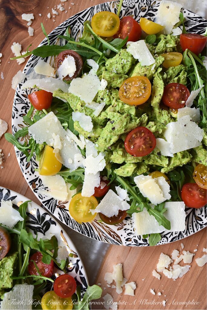 Basil-Dressed Chicken Salad with Tomatoes - This easy-to-assemble salad is the perfect weeknight meal for when you're craving something a little bit lighter. Its blend of peppery arugula and salty parmesan cheese pairs so well with the acidity of halved cherry or grape tomatoes and a sweet, creamy, and flavorful chicken salad made with a fresh basil dressing.