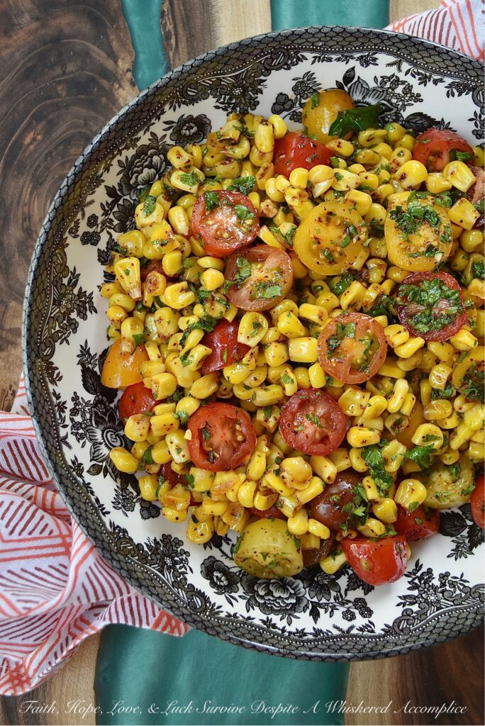 Corn & Tomato Salad with Hot Honey Vinaigrette - This bright and colorful corn and tomato salad is the perfect side dish for almost any busy weeknight dinner, impromptu cookout, or last-minute barbecue. Simply microwave a bag of steam-in-bag corn kernels, halve some cherry tomatoes, and mix the steamed corn and halved tomatoes in an easy-to-make vinaigrette, made with chili-infused hot honey, finely chopped fresh parsley, and a few common pantry seasonings.