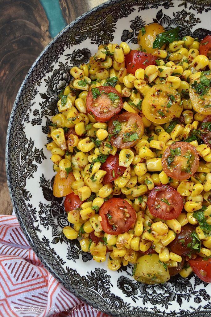 Corn & Tomato Salad with Hot Honey Vinaigrette - This bright and colorful corn and tomato salad is the perfect side dish for almost any busy weeknight dinner, impromptu cookout, or last-minute barbecue. Simply microwave a bag of steam-in-bag corn kernels, halve some cherry tomatoes, and mix the steamed corn and halved tomatoes in an easy-to-make vinaigrette, made with chili-infused hot honey, finely chopped fresh parsley, and a few common pantry seasonings.