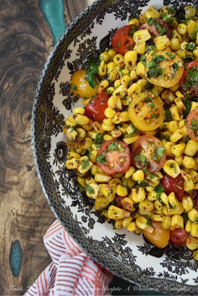 Corn & Tomato Salad with Hot Honey Vinaigrette - This bright and colorful corn and tomato salad is the perfect side dish for almost any busy weeknight dinner, impromptu cookout, or last-minute barbecue. Simply microwave a bag of steam-in-bag corn kernels, halve some cherry tomatoes, and mix the steamed corn and halved tomatoes in an easy-to-make vinaigrette, made with chili-infused hot honey, finely chopped fresh parsley, and a few common pantry seasonings.