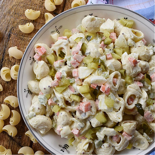 Bread & Butter Pickle Amish Macaroni Salad - Favorite Summertime Pasta Salad Recipes - What would summertime be without an enormous bowl of creamy homemade pasta salad? They're easy to make, can be made for almost any sized crowd, taste so much better than store-bought, and can be made to fit almost any budget. Here, you'll find some of our favorite summer macaroni, tortellini, and couscous pasta salad recipes, just perfect for your next cookout, picnic, reunion, pool party, or barbeque get-together.