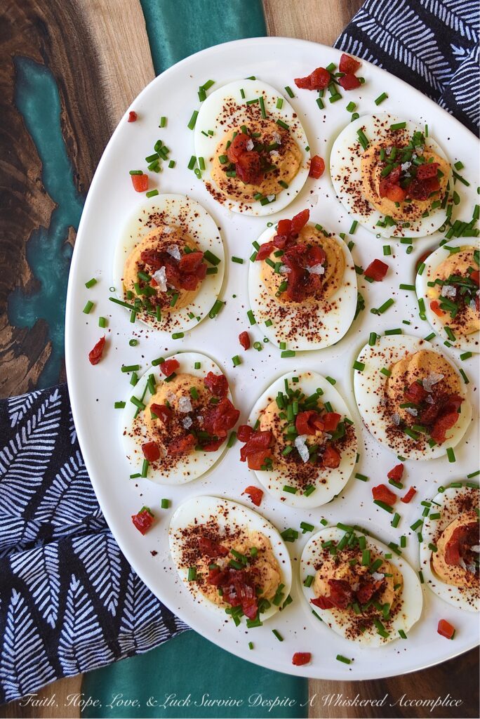 Sweet Chili & Honey Pimento Deviled Eggs - If you're searching for a deviled egg recipe that is just as flavorful as it is gorgeous, look no further. These pimento and chive-topped deviled eggs are stunning, yet packed with flavor as well. Sweet honey, chili powder, flaky sea salt, black pepper, mayonnaise, and a little touch of balsamic vinegar, combined with a jar of diced pimentos and freshly chopped chives, is all that it takes to make an appetizer that absolutely no one will be able to resist.