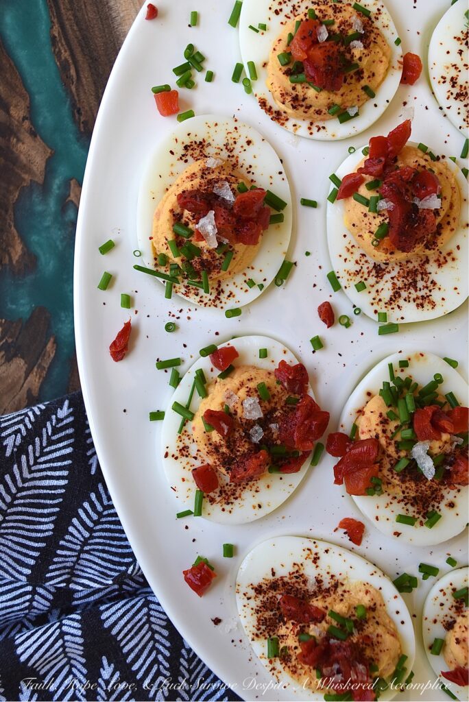 Sweet Chili & Honey Pimento Deviled Eggs - If you're searching for a deviled egg recipe that is just as flavorful as it is gorgeous, look no further. These pimento and chive-topped deviled eggs are stunning, yet packed with flavor as well. Sweet honey, chili powder, flaky sea salt, black pepper, mayonnaise, and a little touch of balsamic vinegar, combined with a jar of diced pimentos and freshly chopped chives, is all that it takes to make an appetizer that absolutely no one will be able to resist.