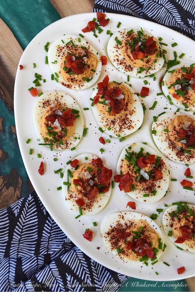 Sweet Chili & Honey Pimento Deviled Eggs - If you're searching for a deviled egg recipe that is just as flavorful as it is gorgeous, look no further. These pimento and chive-topped deviled eggs are stunning, yet packed with flavor as well. Sweet honey, chili powder, flaky sea salt, black pepper, mayonnaise, and a little touch of balsamic vinegar, combined with a jar of diced pimentos and freshly chopped chives, is all that it takes to make an appetizer that absolutely no one will be able to resist.