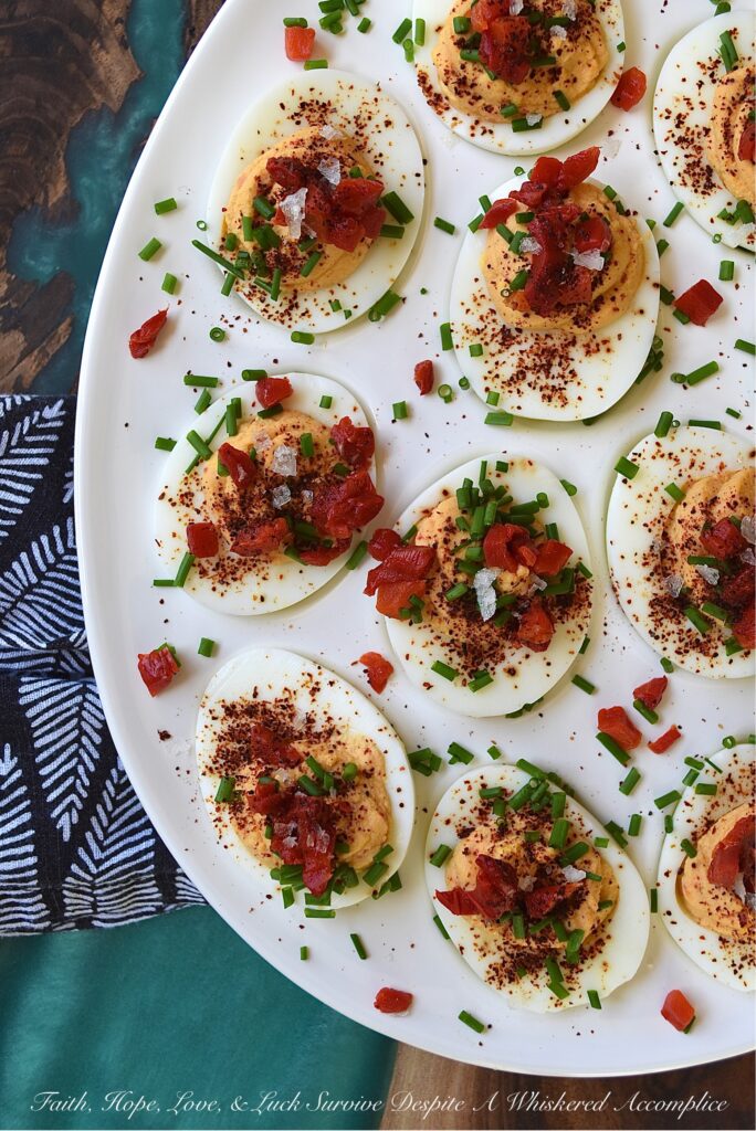 Sweet Chili & Honey Pimento Deviled Eggs - If you're searching for a deviled egg recipe that is just as flavorful as it is gorgeous, look no further. These pimento and chive-topped deviled eggs are stunning, yet packed with flavor as well. Sweet honey, chili powder, flaky sea salt, black pepper, mayonnaise, and a little touch of balsamic vinegar, combined with a jar of diced pimentos and freshly chopped chives, is all that it takes to make an appetizer that absolutely no one will be able to resist.