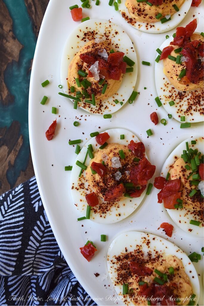 Sweet Chili & Honey Pimento Deviled Eggs - If you're searching for a deviled egg recipe that is just as flavorful as it is gorgeous, look no further. These pimento and chive-topped deviled eggs are stunning, yet packed with flavor as well. Sweet honey, chili powder, flaky sea salt, black pepper, mayonnaise, and a little touch of balsamic vinegar, combined with a jar of diced pimentos and freshly chopped chives, is all that it takes to make an appetizer that absolutely no one will be able to resist.