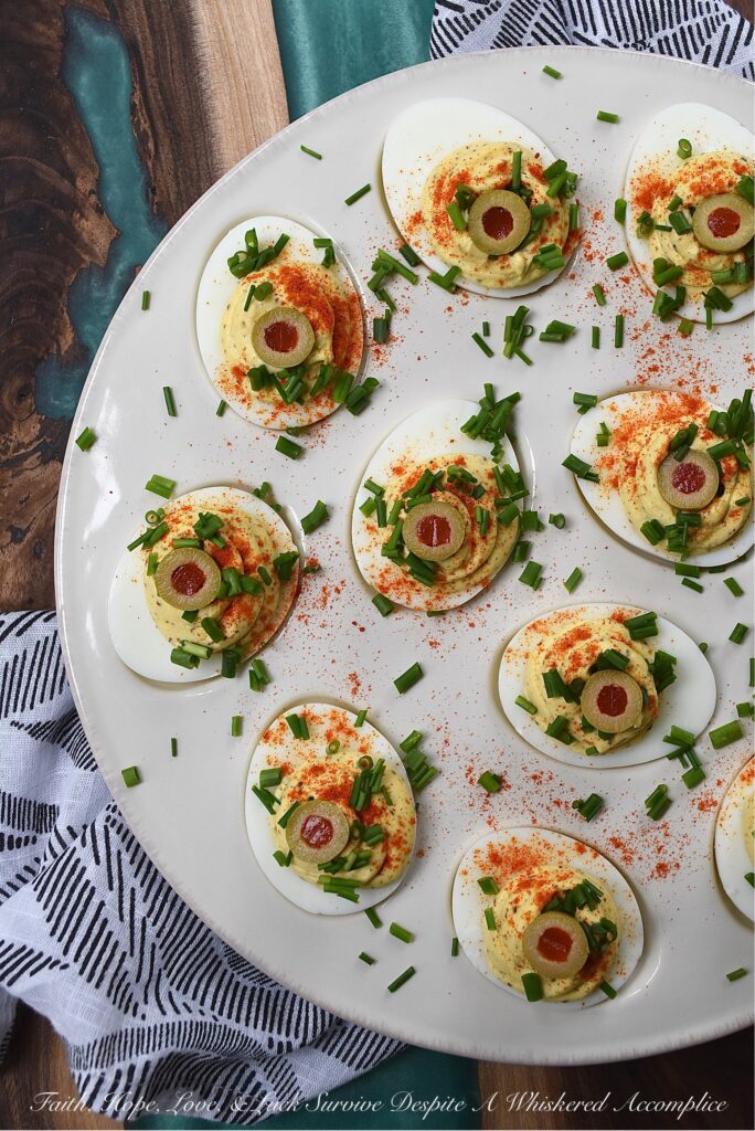 Colleen's Famous Deviled Eggs - This creamy deviled egg recipe is, without a doubt, my most requested recipe of all time. And yes, there's a reason why these deviled eggs are so famous. They have the perfect mayonnaise-to-mustard ratio, black pepper and celery seed for seasoning, paprika for color, and half of a pimento-stuffed green olive for decoration, in addition to finely chopped fresh chives. Simply put, these super creamy deviled eggs are what dreams are made of.
