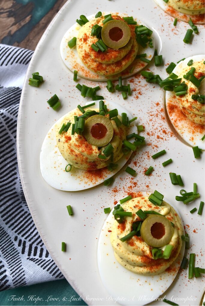 Colleen's Famous Deviled Eggs - This creamy deviled egg recipe is, without a doubt, my most requested recipe of all time. And yes, there's a reason why these deviled eggs are so famous. They have the perfect mayonnaise-to-mustard ratio, black pepper and celery seed for seasoning, paprika for color, and half of a pimento-stuffed green olive for decoration, in addition to finely chopped fresh chives. Simply put, these super creamy deviled eggs are what dreams are made of.