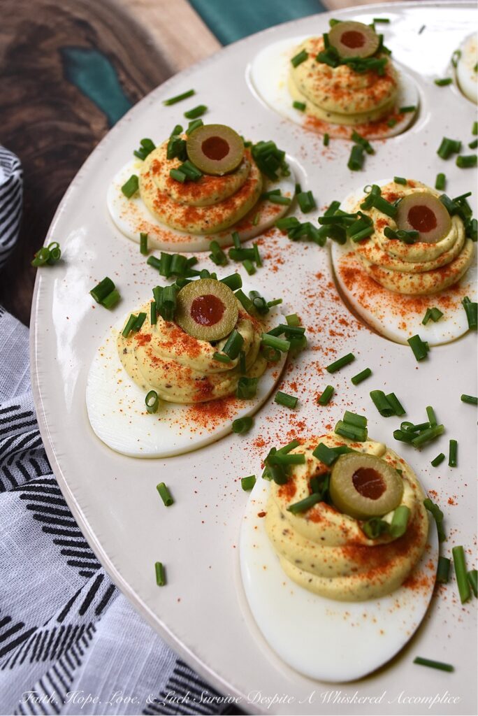 Colleen's Famous Deviled Eggs - This creamy deviled egg recipe is, without a doubt, my most requested recipe of all time. And yes, there's a reason why these deviled eggs are so famous. They have the perfect mayonnaise-to-mustard ratio, black pepper and celery seed for seasoning, paprika for color, and half of a pimento-stuffed green olive for decoration, in addition to finely chopped fresh chives. Simply put, these super creamy deviled eggs are what dreams are made of.