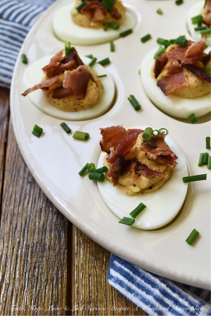 Honey BBQ Seasoned Deviled Eggs with Bacon - These honey barbeque-seasoned deviled eggs with bacon are a must-try. With a touch of honey and the perfect amount of homemade BBQ seasoning, these deviled eggs are a sweet and flavorful addition to almost any meal. And, the crispy bacon and fresh chives that these eggs are garnished with add a nice touch of crunch and freshness to each and every bite. Whether you're serving these as an appetizer or a side dish, this deviled egg recipe is sure to be a crowd-pleaser.