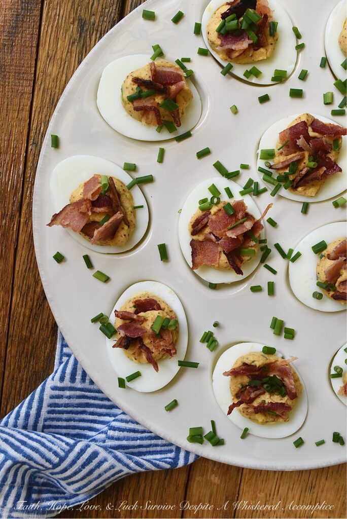 Honey BBQ Seasoned Deviled Eggs with Bacon - These honey barbeque-seasoned deviled eggs with bacon are a must-try. With a touch of honey and the perfect amount of homemade BBQ seasoning, these deviled eggs are a sweet and flavorful addition to almost any meal. And, the crispy bacon and fresh chives that these eggs are garnished with add a nice touch of crunch and freshness to each and every bite. Whether you're serving these as an appetizer or a side dish, this deviled egg recipe is sure to be a crowd-pleaser.