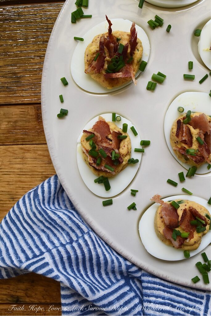 Honey BBQ Seasoned Deviled Eggs with Bacon - These honey barbeque-seasoned deviled eggs with bacon are a must-try. With a touch of honey and the perfect amount of homemade BBQ seasoning, these deviled eggs are a sweet and flavorful addition to almost any meal. And, the crispy bacon and fresh chives that these eggs are garnished with add a nice touch of crunch and freshness to each and every bite. Whether you're serving these as an appetizer or a side dish, this deviled egg recipe is sure to be a crowd-pleaser.