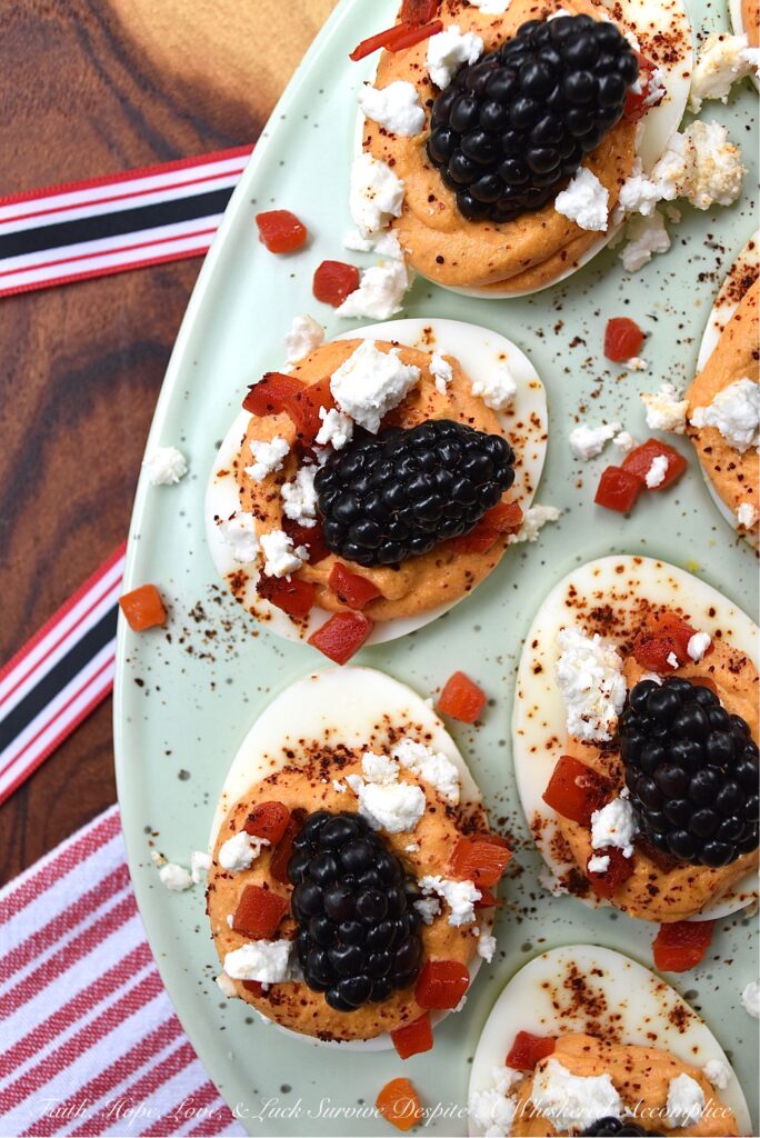 Red, White, & Blue Sweet Pimento Deviled Eggs - These red, white, & blue deviled eggs are the perfect appetizer for your next July 4th celebration. The savory sweetness of the creamy pimento and feta egg filling really helps make this non-traditional deviled egg recipe stand out. And, after these heavenly deviled eggs are garnished with chili powder, pimentos, feta, and perfectly ripe blackberries, they'll be just as gorgeous as they are delicious.
