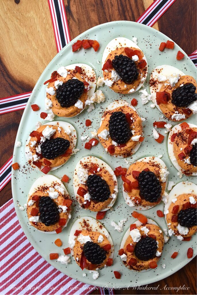 Red, White, & Blue Sweet Pimento Deviled Eggs - These red, white, & blue deviled eggs are the perfect appetizer for your next July 4th celebration. The savory sweetness of the creamy pimento and feta egg filling really helps make this non-traditional deviled egg recipe stand out. And, after these heavenly deviled eggs are garnished with chili powder, pimentos, feta, and perfectly ripe blackberries, they'll be just as gorgeous as they are delicious.