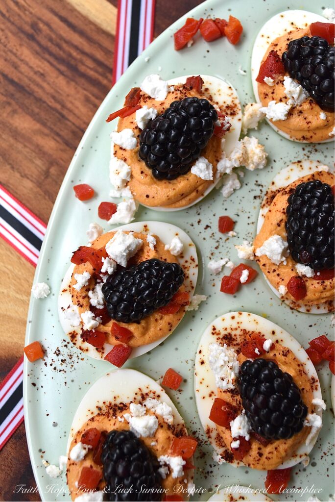 Red, White, & Blue Sweet Pimento Deviled Eggs - These red, white, & blue deviled eggs are the perfect appetizer for your next July 4th celebration. The savory sweetness of the creamy pimento and feta egg filling really helps make this non-traditional deviled egg recipe stand out. And, after these heavenly deviled eggs are garnished with chili powder, pimentos, feta, and perfectly ripe blackberries, they'll be just as gorgeous as they are delicious.