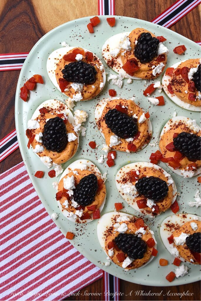 Red, White, & Blue Sweet Pimento Deviled Eggs - These red, white, & blue deviled eggs are the perfect appetizer for your next July 4th celebration. The savory sweetness of the creamy pimento and feta egg filling really helps make this non-traditional deviled egg recipe stand out. And, after these heavenly deviled eggs are garnished with chili powder, pimentos, feta, and perfectly ripe blackberries, they'll be just as gorgeous as they are delicious.