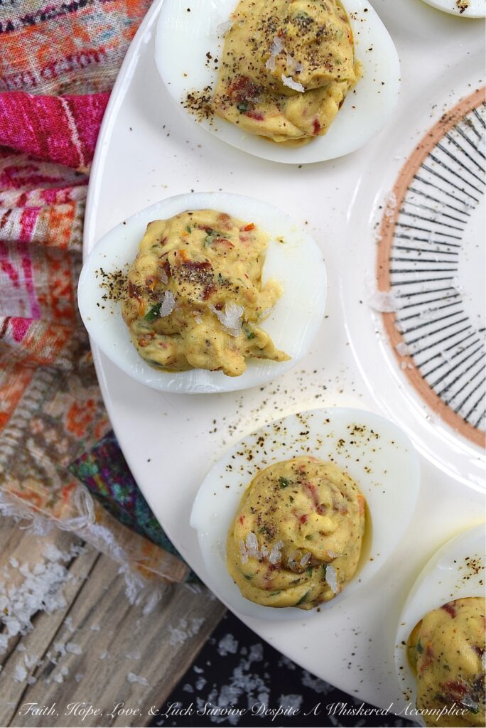 Fresh Basil & Sun-Dried Tomato Deviled Eggs - Fresh basil is the key ingredient to this simple yet extraordinary deviled egg recipe. When paired with very finely chopped sun-dried tomatoes, it immediately helps to make a winning impression on anyone lucky enough to scarf down one of these eggs before they all disappear. And yes, they will all disappear pretty quickly, so perhaps you might want to consider making a double batch.