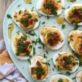Bacon & Chive Deviled Eggs with Hot Honey - Deviled eggs are a classic crowd-pleaser and perfect for warm weather. If you're thinking about hosting a summer picnic or gathering, you definitely need to include some of these bacon-filled deviled eggs on the menu. They're topped with paprika, fresh chives, and even more bacon for a delicious twist on the classic recipe. And for an extra kick of flavor, they're drizzled with sweet and spicy hot honey infused with chilies.