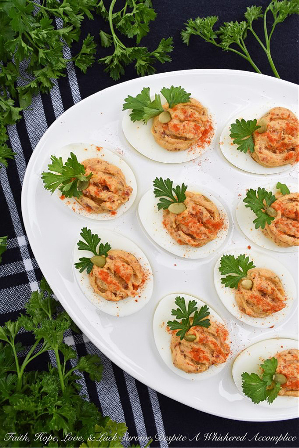 Bacon & Paprika Pumpkin Deviled Eggs - When you're searching for an autumn party deviled egg recipe that not only tastes amazing but looks festive, this is the recipe you need. Not only do crispy bacon and paprika add tons of flavor, as well as texture, but parsley leaves and roasted salted pumpkin seeds give these little pumpkin-shaped deviled eggs the perfect fall party appearance. They're the perfect excuse to throw a party.