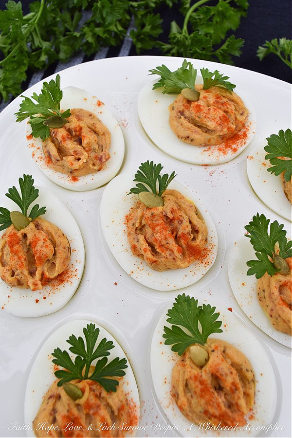 Bacon & Paprika Pumpkin Deviled Eggs - When you're searching for an autumn party deviled egg recipe that not only tastes amazing but looks festive, this is the recipe you need. Not only do crispy bacon and paprika add tons of flavor, as well as texture, but parsley leaves and roasted salted pumpkin seeds give these little pumpkin-shaped deviled eggs the perfect fall party appearance. They're the perfect excuse to throw a party.