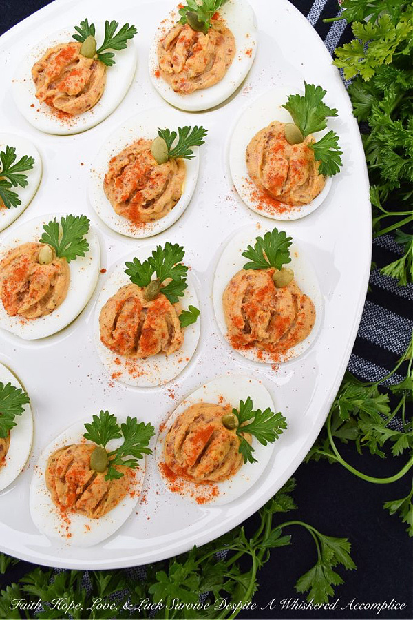 Bacon & Paprika Pumpkin Deviled Eggs - When you're searching for an autumn party deviled egg recipe that not only tastes amazing but looks festive, this is the recipe you need. Not only do crispy bacon and paprika add tons of flavor, as well as texture, but parsley leaves and roasted salted pumpkin seeds give these little pumpkin-shaped deviled eggs the perfect fall party appearance. They're the perfect excuse to throw a party.
