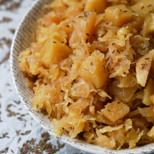 Autumn Crockpot Apple Sauerkraut - Give your crockpot sauerkraut the taste of autumn with the addition of seasonal apples, brown sugar, Oktoberfest beer, diced onion, and caraway seeds.