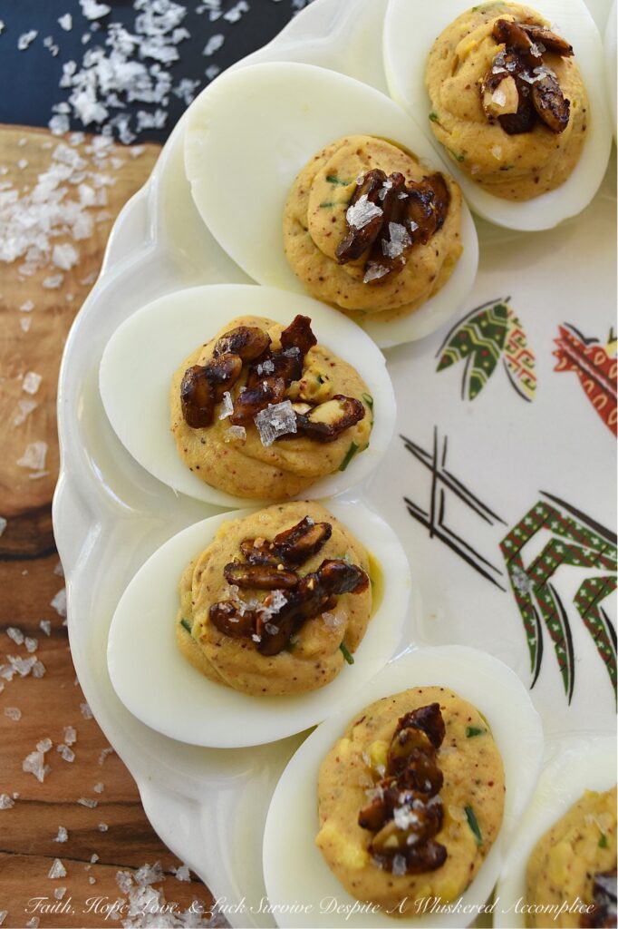 Sweet Chili Candied Pumpkin Seed Deviled Eggs - Deviled eggs are a classic holiday treat, and this version takes it up a notch with a creamy, flavorful chili powder seasoned filling, lightly sweetened with just a touch of honey. Topped with easy-to-make buttery roasted and candied pumpkin seeds and a touch of flaky sea salt, these deviled eggs are the perfect fall side dish or appetizer. They'll add a special touch to your holiday table or buffet and make a wonderful addition to your next gathering.