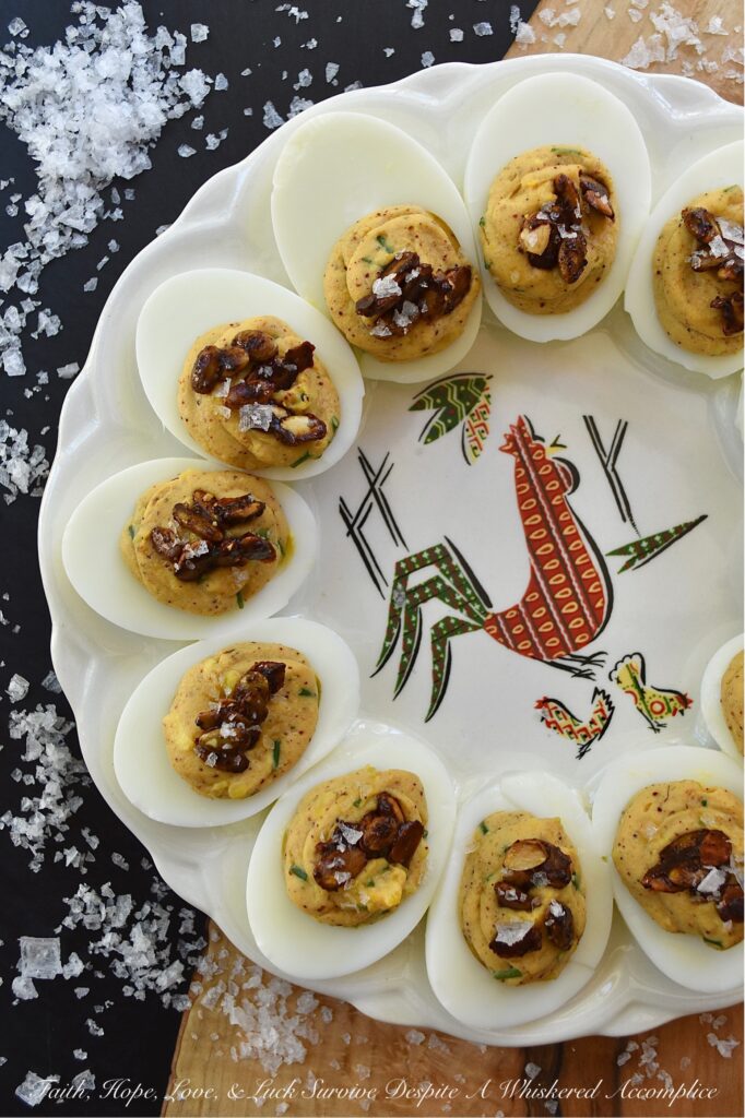 Sweet Chili Candied Pumpkin Seed Deviled Eggs - Deviled eggs are a classic holiday treat, and this version takes it up a notch with a creamy, flavorful chili powder seasoned filling, lightly sweetened with just a touch of honey. Topped with easy-to-make buttery roasted and candied pumpkin seeds and a touch of flaky sea salt, these deviled eggs are the perfect fall side dish or appetizer. They'll add a special touch to your holiday table or buffet and make a wonderful addition to your next gathering.