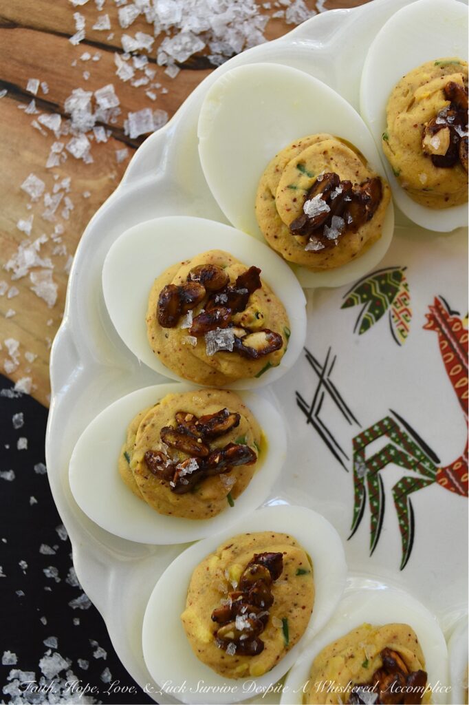 Sweet Chili Candied Pumpkin Seed Deviled Eggs - Deviled eggs are a classic holiday treat, and this version takes it up a notch with a creamy, flavorful chili powder seasoned filling, lightly sweetened with just a touch of honey. Topped with easy-to-make buttery roasted and candied pumpkin seeds and a touch of flaky sea salt, these deviled eggs are the perfect fall side dish or appetizer. They'll add a special touch to your holiday table or buffet and make a wonderful addition to your next gathering.