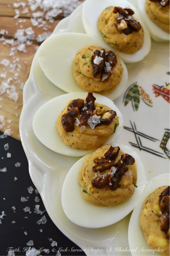 Sweet Chili Candied Pumpkin Seed Deviled Eggs - Deviled eggs are a classic holiday treat, and this version takes it up a notch with a creamy, flavorful chili powder seasoned filling, lightly sweetened with just a touch of honey. Topped with easy-to-make buttery roasted and candied pumpkin seeds and a touch of flaky sea salt, these deviled eggs are the perfect fall side dish or appetizer. They'll add a special touch to your holiday table or buffet and make a wonderful addition to your next gathering.