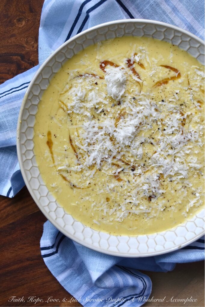 Parmesan Pumpkin Soup with Hot Honey - Parmesan Pumpkin Soup with Hot Honey is the perfect fall soup to warm you up on a chilly autumn night. Start by peeling and cubing fresh pumpkin and simmering it in a stockpot with chicken broth and seasonings until the pumpkin is tender. Once the pumpkin has cooked, add some freshly grated parmesan, half and half, and heavy whipping cream. Purée the soup until smooth and creamy, then ladle it into bowls. Top each bowl with a drizzle of honey infused with chiles for a hint of heat, and then sprinkle on some freshly grated parmesan cheese for a salty, nutty flavor.
