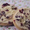 Cranberry and White Chocolate Frosted Biscuit Cookies - This holiday season, enjoy the deliciousness of a soft, buttery biscuit-based cookie combined with a light and creamy butter and cream cheese frosting, the zesty taste of lemon, and the sweetness of white chocolate and dried cranberries. With every bite, you'll experience a burst of sweet delightful flavors.