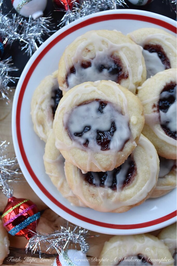 Raspberry-Cranberry Thumbprint Shortbread Cookies - These festive raspberry and cranberry thumbprint cookies, topped with a simple powdered sugar vanilla glaze, are a delicious treat that combines buttery, sweet, and fruity flavors to make them utterly irresistible. And, with the ability to use any brand or variety of mixed berry jam, jelly, or preserves, you can create an array of different flavors for your cookie tray or platter. Whether you bake these cookies for a special occasion or just because you're craving something sweet, they're sure to be a hit.