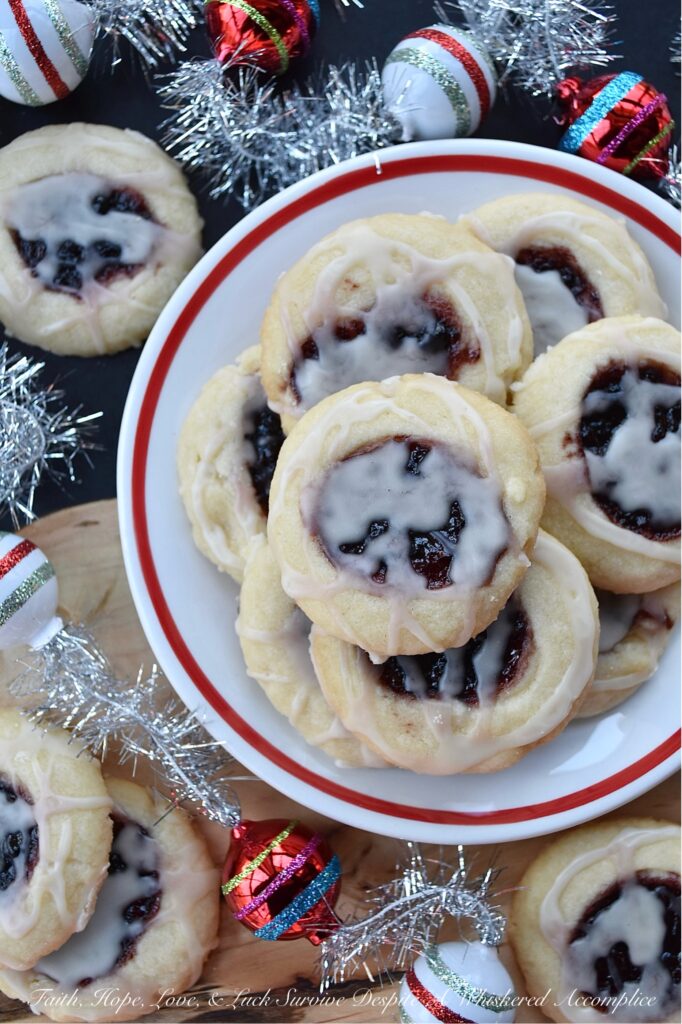 Raspberry-Cranberry Thumbprint Shortbread Cookies - These festive raspberry and cranberry thumbprint cookies, topped with a simple powdered sugar vanilla glaze, are a delicious treat that combines buttery, sweet, and fruity flavors to make them utterly irresistible. And, with the ability to use any brand or variety of mixed berry jam, jelly, or preserves, you can create an array of different flavors for your cookie tray or platter. Whether you bake these cookies for a special occasion or just because you're craving something sweet, they're sure to be a hit.