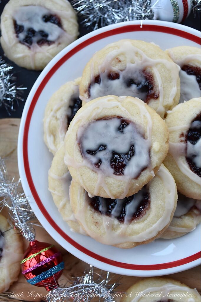 Raspberry-Cranberry Thumbprint Shortbread Cookies - These festive raspberry and cranberry thumbprint cookies, topped with a simple powdered sugar vanilla glaze, are a delicious treat that combines buttery, sweet, and fruity flavors to make them utterly irresistible. And, with the ability to use any brand or variety of mixed berry jam, jelly, or preserves, you can create an array of different flavors for your cookie tray or platter. Whether you bake these cookies for a special occasion or just because you're craving something sweet, they're sure to be a hit.