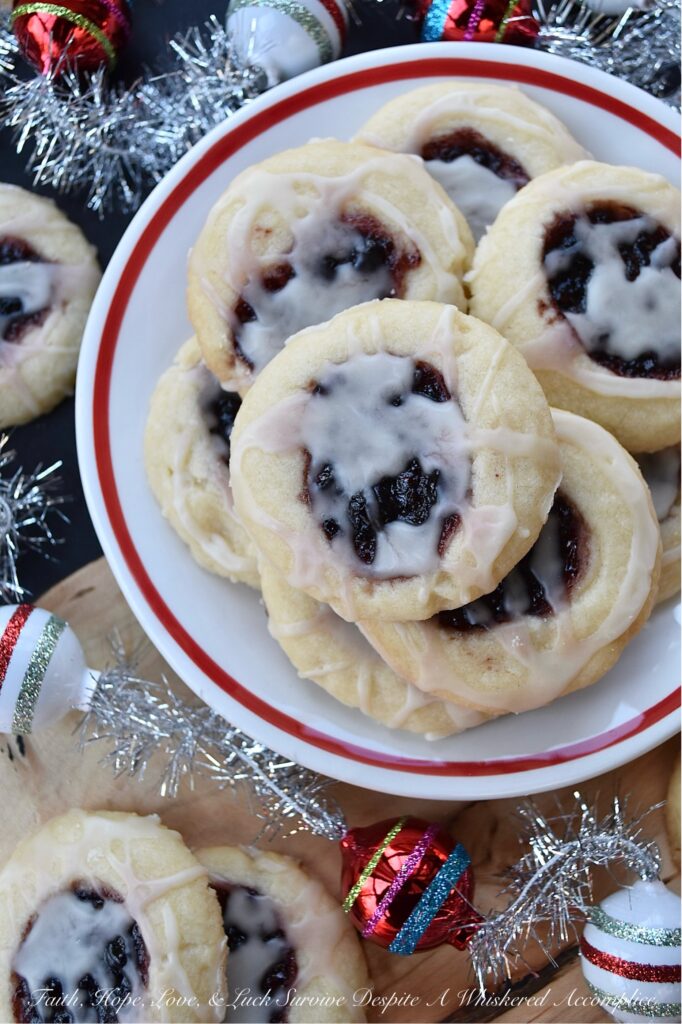 Raspberry-Cranberry Thumbprint Shortbread Cookies - These festive raspberry and cranberry thumbprint cookies, topped with a simple powdered sugar vanilla glaze, are a delicious treat that combines buttery, sweet, and fruity flavors to make them utterly irresistible. And, with the ability to use any brand or variety of mixed berry jam, jelly, or preserves, you can create an array of different flavors for your cookie tray or platter. Whether you bake these cookies for a special occasion or just because you're craving something sweet, they're sure to be a hit.