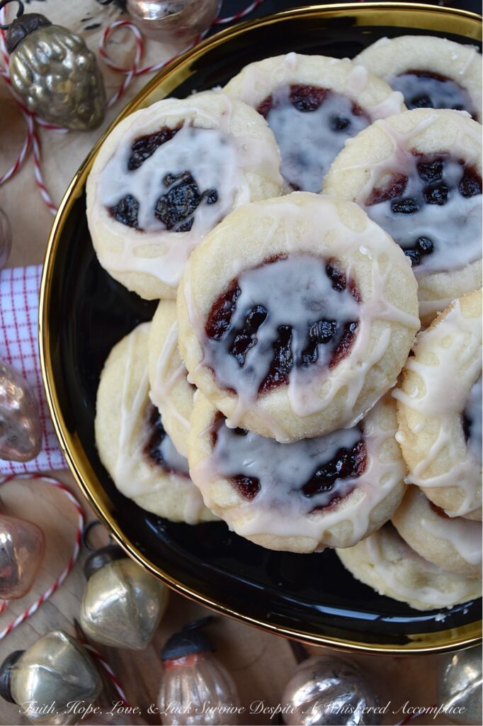 Orange Mixed Berry Glazed Thumbprint Cookies - These gorgeous mixed berry preserves-filled orange thumbprint cookies, topped with a simple orange and vanilla extract powdered glaze, are a delicious treat that combines buttery, sweet, citrusy, and fruity flavors to create a cookie worthy of any cookie tray or platter. Whether you bake these cookies during the holidays or just because you’re craving something sweet, they're guaranteed to be an instant hit with anyone who tries them.
