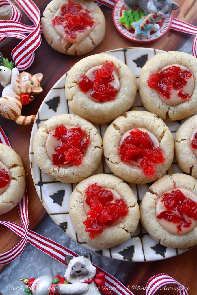 Cherry Liqueur Icing Filled Thumbprint Cookies - After baking, these buttery thumbprint cookies are filled with a smooth powdered sugar cherry liqueur icing and sprinkled with finely chopped maraschino cherries. The result is a delicious, bite-sized treat that is as attractive as it is delicious. These cookies are just the cookie recipe you need to add some gorgeous holiday color to your cookie tray this season.