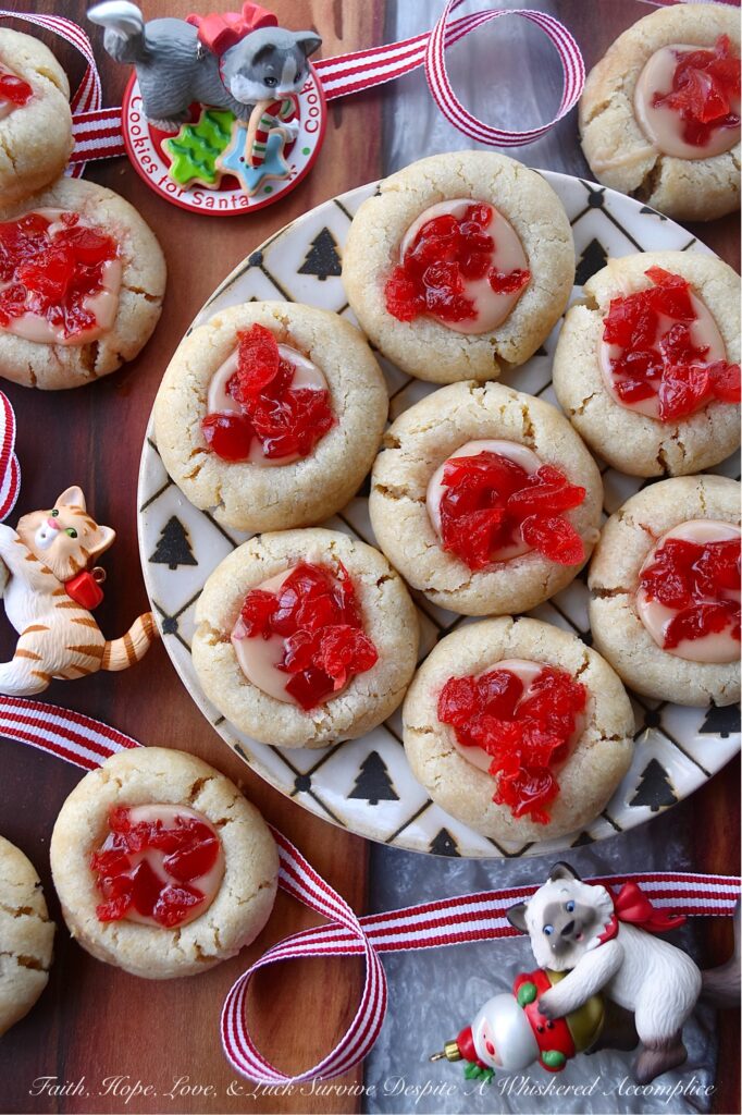 Cherry Liqueur Icing Filled Thumbprint Cookies - After baking, these buttery thumbprint cookies are filled with a smooth powdered sugar cherry liqueur icing and sprinkled with finely chopped maraschino cherries. The result is a delicious, bite-sized treat that is as attractive as it is delicious. These cookies are just the cookie recipe you need to add some gorgeous holiday color to your cookie tray this season.