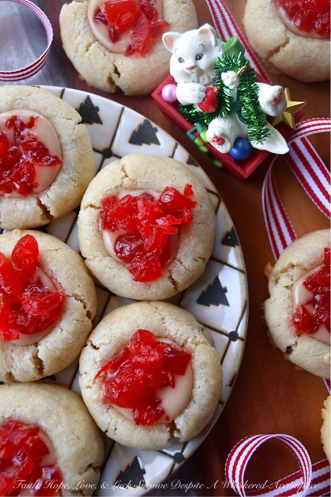 Cherry Liqueur Icing Filled Thumbprint Cookies - After baking, these buttery thumbprint cookies are filled with a smooth powdered sugar cherry liqueur icing and sprinkled with finely chopped maraschino cherries. The result is a delicious, bite-sized treat that is as attractive as it is delicious. These cookies are just the cookie recipe you need to add some gorgeous holiday color to your cookie tray this season.