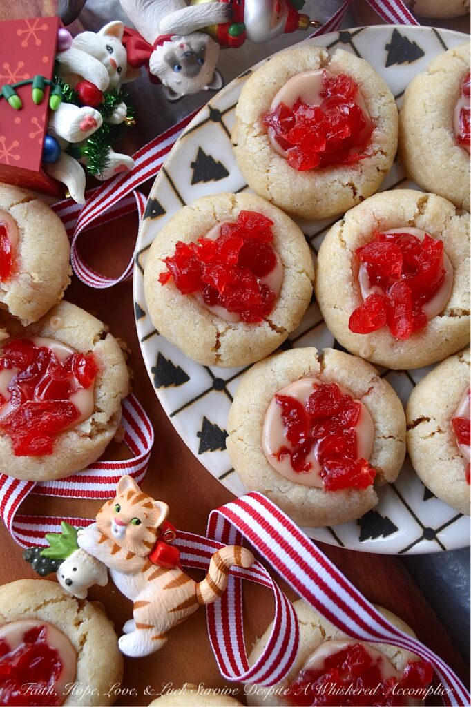 Cherry Liqueur Icing Filled Thumbprint Cookies - After baking, these buttery thumbprint cookies are filled with a smooth powdered sugar cherry liqueur icing and sprinkled with finely chopped maraschino cherries. The result is a delicious, bite-sized treat that is as attractive as it is delicious. These cookies are just the cookie recipe you need to add some gorgeous holiday color to your cookie tray this season.