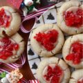 Cherry Liqueur Icing Filled Thumbprint Cookies - After baking, these buttery thumbprint cookies are filled with a smooth powdered sugar cherry liqueur icing and sprinkled with finely chopped maraschino cherries. The result is a delicious, bite-sized treat that is as attractive as it is delicious. These cookies are just the cookie recipe you need to add some gorgeous holiday color to your cookie tray this season.