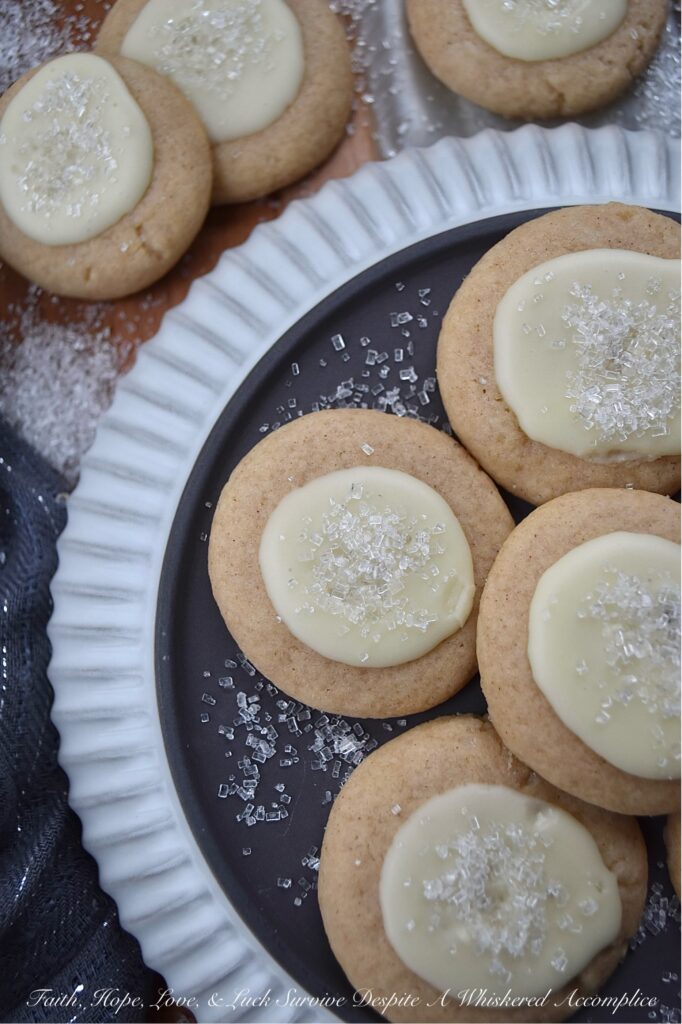 Snowy Eggnog Melt-Away Cookies - One bite of these sweet buttery melt-in-your-mouth cookies, and you'll be transported to a winter wonderland. With their dusting of white sparkling sugar snow, simple eggnog and powdered sugar icing, and warm nutmeg and cinnamon spices, these Snowy Eggnog Melt-Away Cookies are the ideal treat for the chilly holiday season.