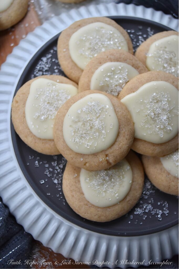 Snowy Eggnog Melt-Away Cookies - One bite of these sweet buttery melt-in-your-mouth cookies, and you'll be transported to a winter wonderland. With their dusting of white sparkling sugar snow, simple eggnog and powdered sugar icing, and warm nutmeg and cinnamon spices, these Snowy Eggnog Melt-Away Cookies are the ideal treat for the chilly holiday season.